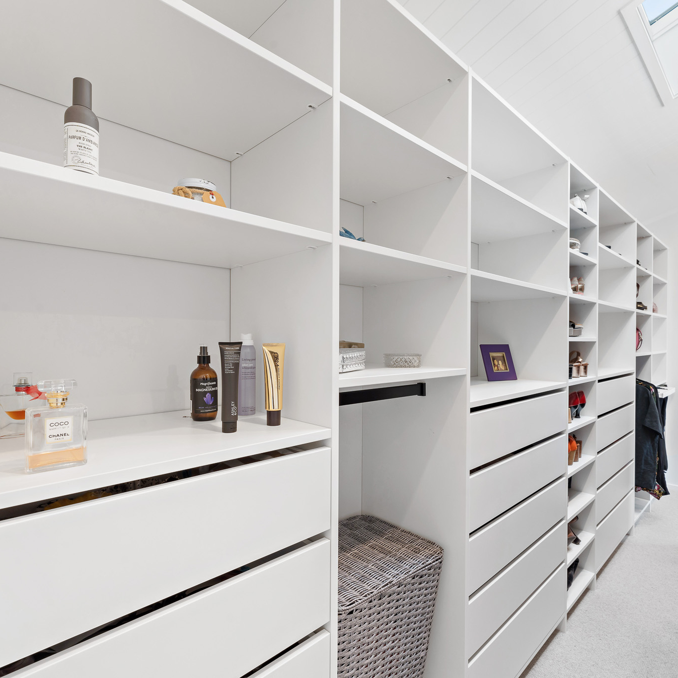 White Flex wardrobe organiser walk-in, you can see 3 drawer towers, a shoe tower, and some perfume and makeup bottles on the shelf