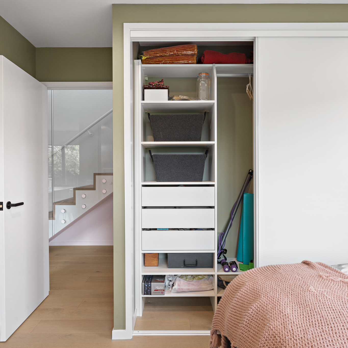 Bedroom showing White Aristo sliding wardrobe doors, open and you can see the Flex wardrobe organiser inside